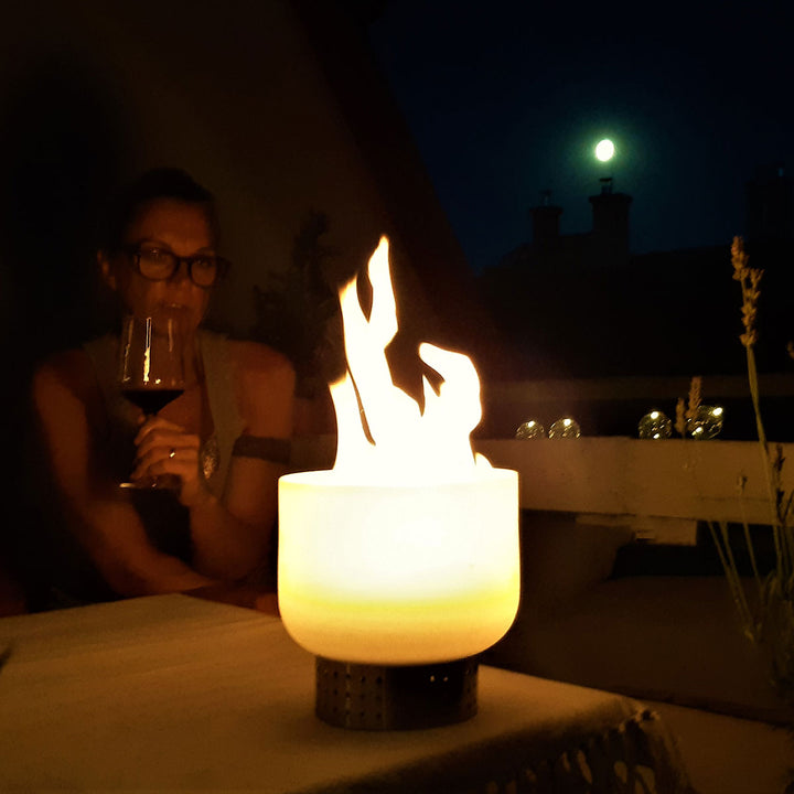 QFlame Quarzglas Tischfeuerschale QTable Edelstahl 20cm in betrieb mit Frau im Hintergrund